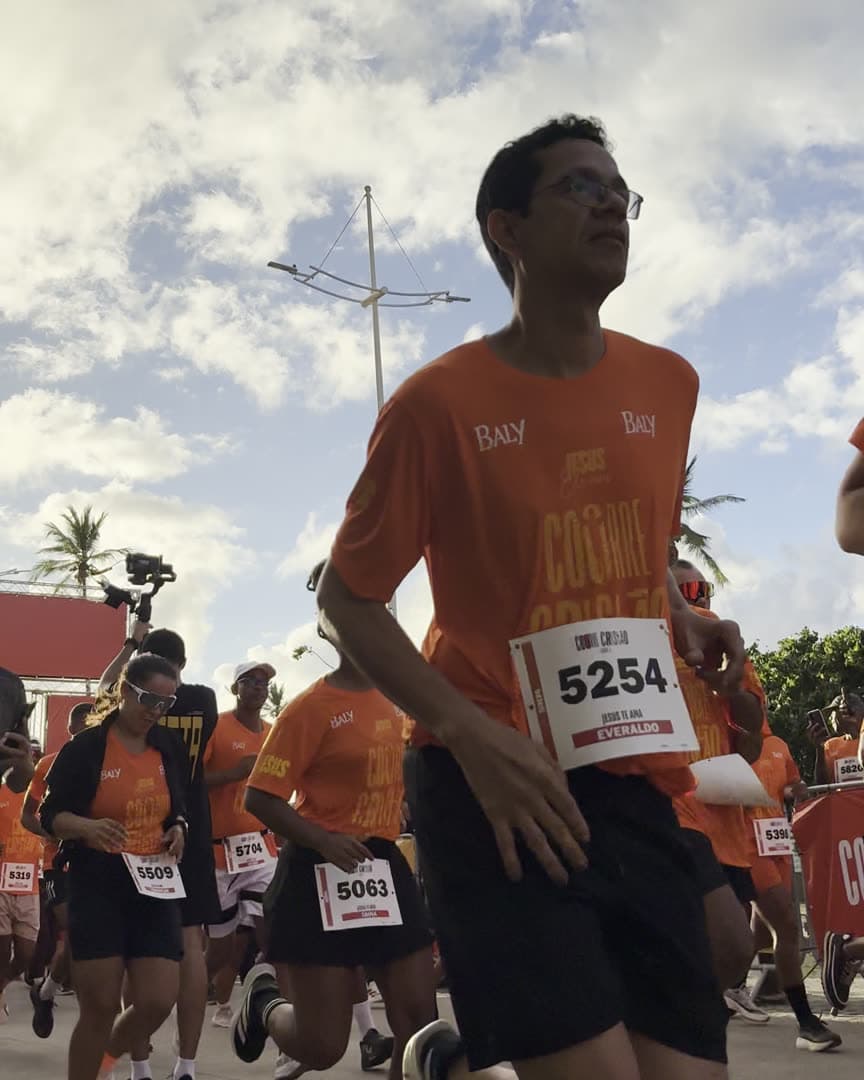 Corredores do Corre Cristão com a camisa laranja do grupo durante uma prova